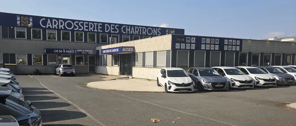 La façade de la Carrosserie des Chartrons, boulevard Alfred Daney : l'enseigne, l'entrée Accueil et le parking devant l'atelier